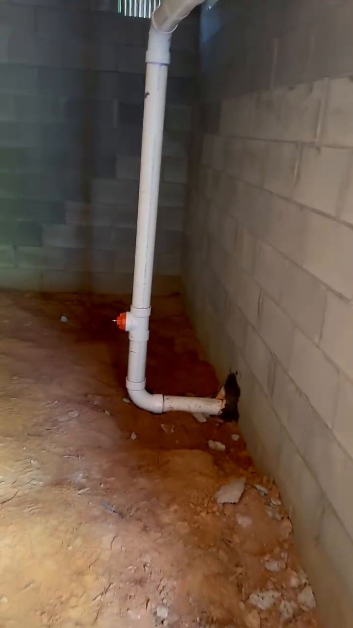 PVC drain line along block wall